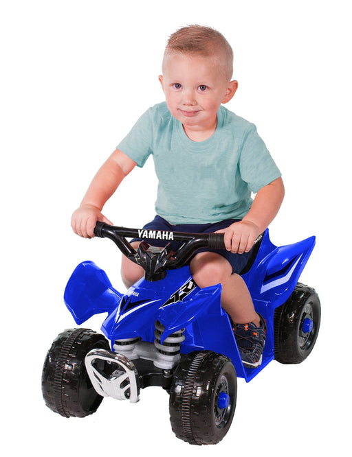 Little boy riding on a Blue Yamaha Mini Quad Bike TRX ATV with white background
