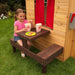 Modern Outdoor Cubby House - little girl having snack in the espresso table