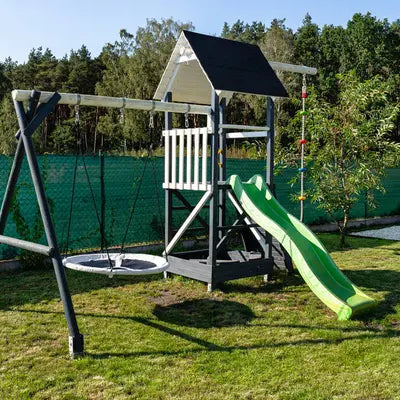 Wooden backyard swing set installed with safety surfacing and clearance around the frame