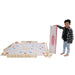 image of a boy holding the giant scrabble box standing next to the giant scrabble mat game set up