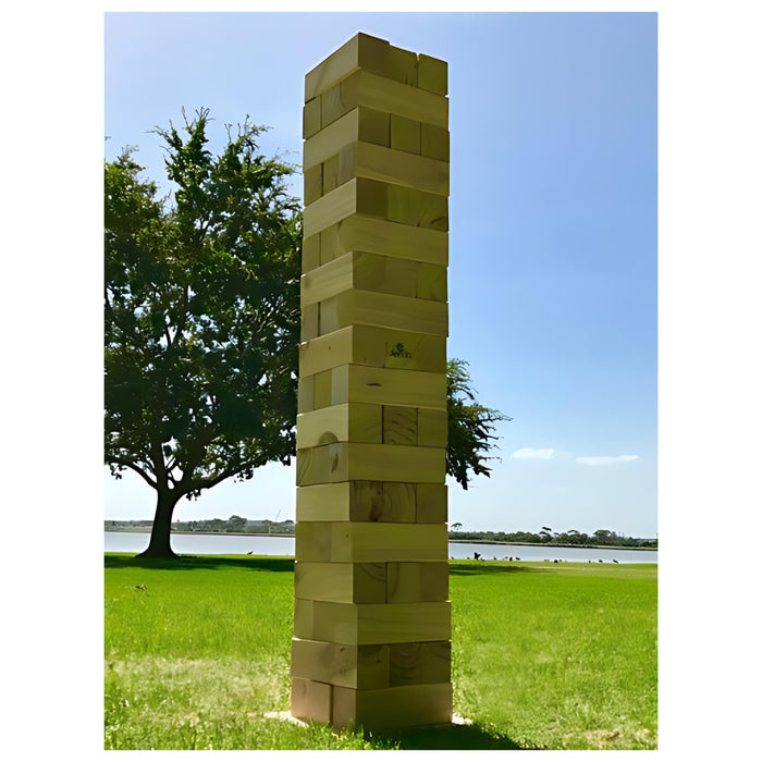 close up image of the 127 cm giant jenga on grass with a pond in the background