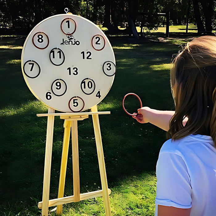 a girl playing with the giant hookey board outside with the hookey board on an easel