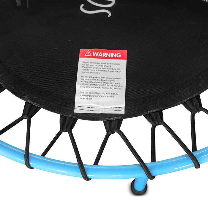 Black trampoline with a warning label on a white background