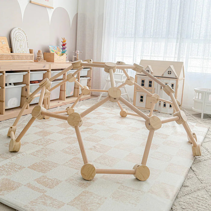 Wooden geometric play structure in a room with toys and furniture.