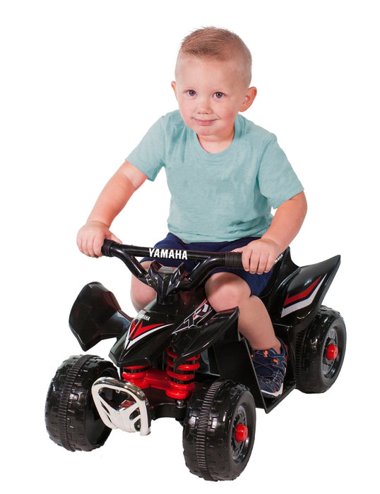 Little boy riding on a Red Yamaha Mini Quad Bike TRX ATV with white background