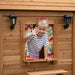 Close up image of a little girl waving from the window of Aspen Cubby Playhouse