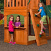Image of 3 little girls, one climbing the rock climbing wall and 2 on the store of Backyard Discovery Atlantis Play Centre Swing And Play Set