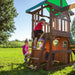 Close up image of a little boy climbing on the wooden ladder and 3 littlle kids playing on the snack window of Lakewood Swing And Play Set in an outdoor background