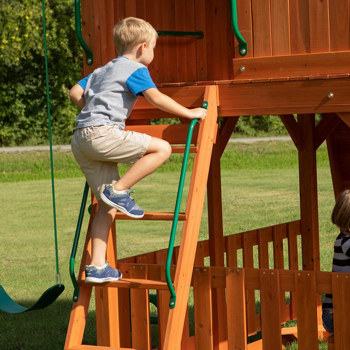 Close up image of a little boy climbing the wooden ladder of Skyfort II Swing And Play Set