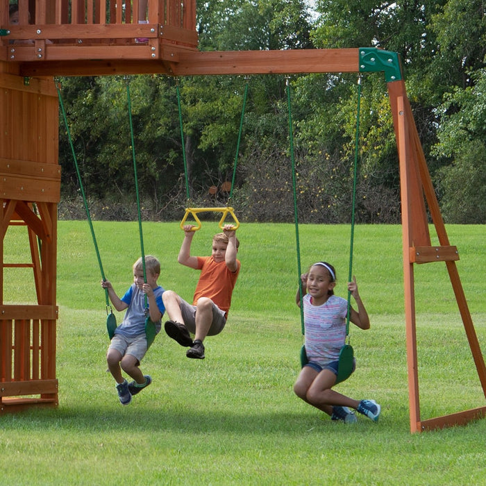Close up image of 3 little kids swinging on the swings and trapeze of Skyfort II Swing And Play Set