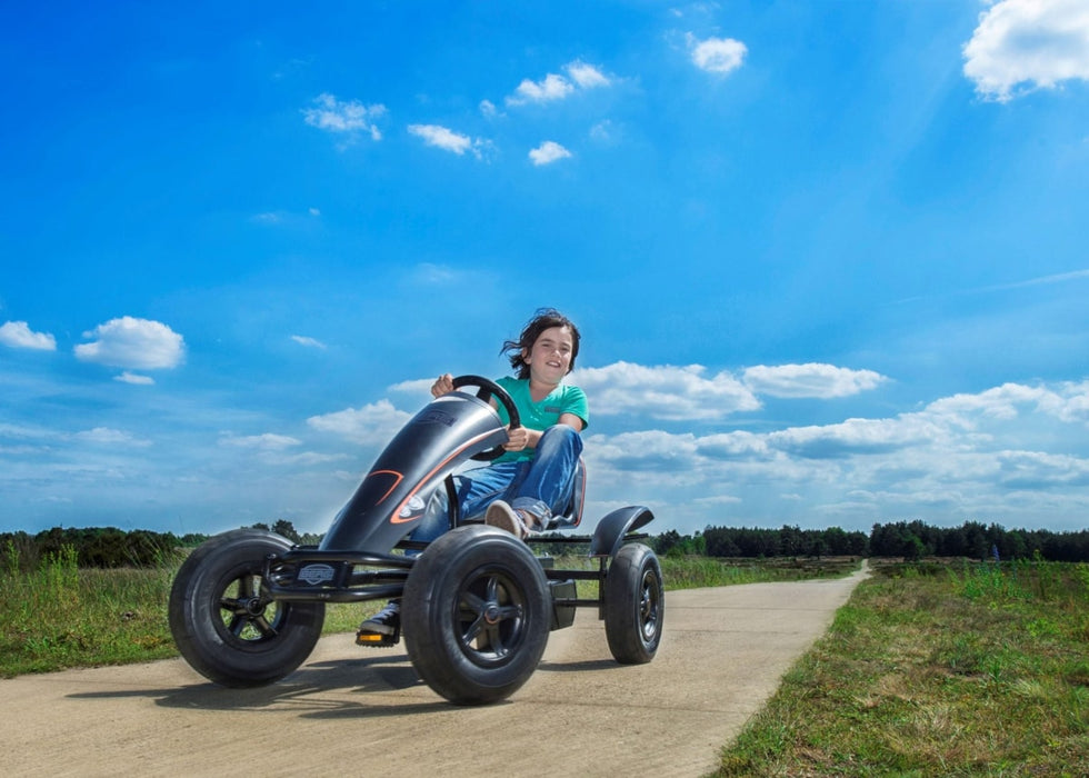Image of a little kid riding the Berg BFR Black Go Kart with an outdoor background