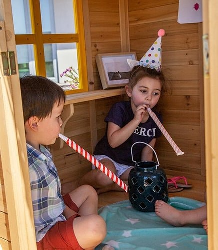 Close up image of 2 little kids playing inside the Archie Cubby House with slide