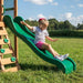 Close up image of a little girl sliding on the green slide of the Buckley Hill Play Set in outdoor background