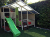 Mega Triplex Cubby House - simple design with tables and chairs; green slide