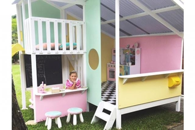 Mega Triplex Cubby House - princess like designed. painted in neon colours like neon green, neon pink, neon purple for the roof, and yellow. little girl smiling inside the snack station