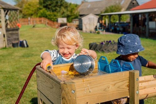 kids playing with the water run in a big grassed garden