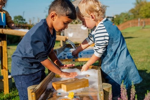 two children playing with the forest water run