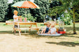Image of a little boy arranging a snack in the Picnic Table With Umbrella and 2 little kids sitting on the mat outdoor