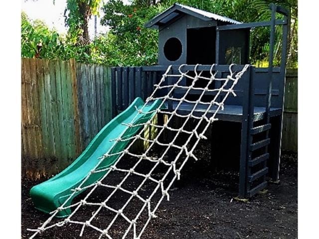 The Adventurer Cubby House - black painted with green slide and climbing net